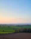 Portrait view of rolling english countryside with blue sky and green fields Royalty Free Stock Photo