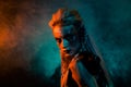 Portrait of viking shield maiden girl fearless angry glance blue orange lights mist isolated on dark background