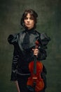 Portrait of a violinist in Victorian-style black dress holding a violin against dark vintage background. Poster for Royalty Free Stock Photo