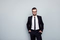 Portrait of virile masculine mature smart expert confident employee keeping hands in pockets wearing white classic shirt black ti Royalty Free Stock Photo