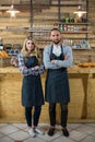 Portrait of waiter and waitress standing with arms crossed at counter Royalty Free Stock Photo