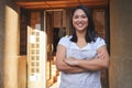 Portrait, waitress and Asian woman with arms crossed at restaurant, coffee shop or store. Face, smile and confident