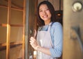 Portrait, waitress and Asian woman at door of restaurant, coffee shop or retail store. Face, smile or confident barista