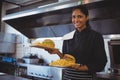 Portrait of waitress with French fries and burger in cafe