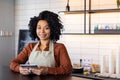 Portrait waitress of a small business owner of a cafe, woman in apron smiles and looks at camera with a tablet computer