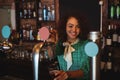 Portrait of waitress using beer tap at counter Royalty Free Stock Photo