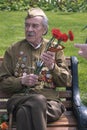 Portrait of a war veteran. He holds flowers.