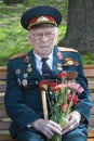 Portrait of a war veteran. He holds flowers.