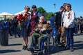 Portrait of a war veteran. Young people pose by him for a photo.