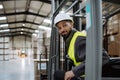 Portrait of warehouse worker driving forklift. Warehouse worker preparing products for shipmennt, delivery, checking Royalty Free Stock Photo