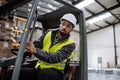 Portrait of warehouse worker driving forklift. Warehouse worker preparing products for shipmennt, delivery, checking Royalty Free Stock Photo