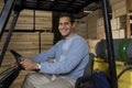Portrait Of A Warehouse Worker Sitting In Forklift Royalty Free Stock Photo