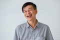 Portrait of warm personality senior older Asian man in casual dress friendly pose and laughing with happy and successful feeling