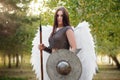 Portrait of a warrior woman in chain mail with steel bracers and wings behind her back. Royalty Free Stock Photo