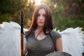 Portrait of a warrior woman in chain mail with steel bracers and wings behind her back.