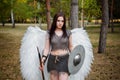 Portrait of a warrior woman in chain mail with steel bracers and wings behind her back.