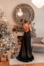 Portrait of a wealthy mature woman with evening make-up and hairstyle posing in a black dress on the background of the Royalty Free Stock Photo