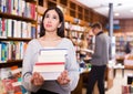 Portrait of weary girl with stack of books