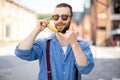 Portrait of weird stylish businessman with banana outdoors