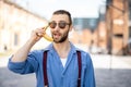 Portrait of weird stylish businessman with banana outdoors