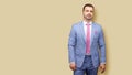 Portrait of well dressed Caucasian young man on light peach background Royalty Free Stock Photo