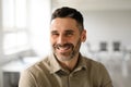 Portrait of well dressed middle aged businessman smiling confidently while standing in light modern office interior Royalty Free Stock Photo