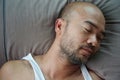 Portrait of bald beard Japanese sleeping man on grey pillow Royalty Free Stock Photo