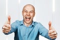 Portrait White bald man in blue shirt showing thumbs up and smiling Royalty Free Stock Photo