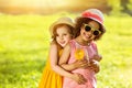 Portrait of a white and Black girl friends in a summer park. Friendly warm hugs of children