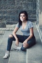 Portrait of white Caucasian beautiful young brunette girl with light blue green eyes in ripped jeans. Teenager blowing bubble gum Royalty Free Stock Photo