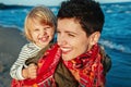 Portrait of white Caucasian mother and daughter baby girl hugging smiling laughing playing running on ocean sea beach Royalty Free Stock Photo