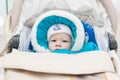 Baby in a perambulator baby carriage at a winter day Royalty Free Stock Photo