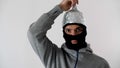 Portrait of a white man  in a black balaclava puts on a foil hat. 5G tower radiation protection. Royalty Free Stock Photo