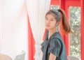 Portrait of White skin Asin woman with long ponytail sitting in a red coffee shop