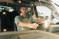 Portrait through windshield of happy customer male client putting hand on steering wheel, smiling looking at camera Royalty Free Stock Photo