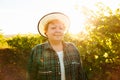portrait of winemaker woman with hat looking at camera at sunset.