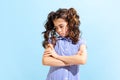 Portrait of winsome little girl,school age kid in summer dress isolated over blue background. Concept of children