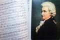 A portrait of Wolfgang Amadeus Mozart on the opened sheet music. Royalty Free Stock Photo