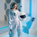 Portrait of a woman astronaut in a space suit, dreamy look up. Futuristic astronaut on Board the spacecraft.