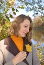 Portrait of a woman with an autumn leaf of tulip lyriodendron. Fall Royalty Free Stock Photo