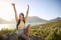 Portrait Of Woman With Backpack On Vacation Taking A Break On Hike By Sea Stretching Arms In The Air Royalty Free Stock Photo