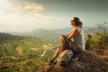 Portrait of woman with backpacker sitting on top of the mountain