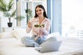 Portrait of woman on bad at home and using laptop while eating healthy salad. Royalty Free Stock Photo