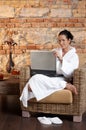 Portrait of woman in bathrobe with laptop