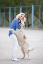 Portrait of a woman with beautiful dog playing outdoors. Royalty Free Stock Photo