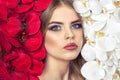 Portrait of a woman with beautiful make-up holds a white and red orchid in his hands. Royalty Free Stock Photo