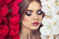 Portrait of a woman with beautiful make-up holds a white and red orchid in his hands. Royalty Free Stock Photo