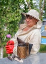 Portrait of a woman beekeeper with flower