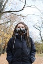 Portrait of a Woman in a black jacket with dreadlocks and a gas mask with spikes. Woman posing in autumn park Royalty Free Stock Photo