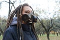 Portrait of a Woman in a black jacket with dreadlocks and a gas mask with spikes. Woman posing in autumn park Royalty Free Stock Photo